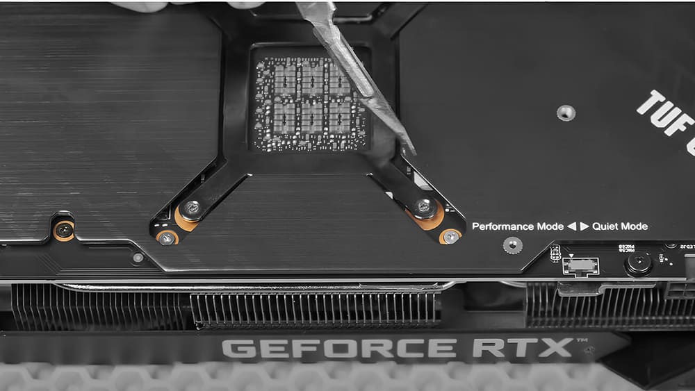 Мастер снимает заднюю крышку с GeForce RTX, используя отвертку для доступа к компонентам.