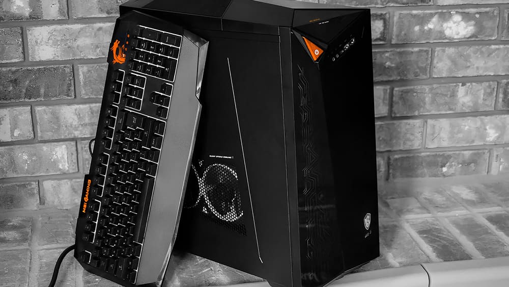 Компьютер MSI с клавиатурой на фоне кирпичной стены, готовый к разборке для ремонта или диагностики.