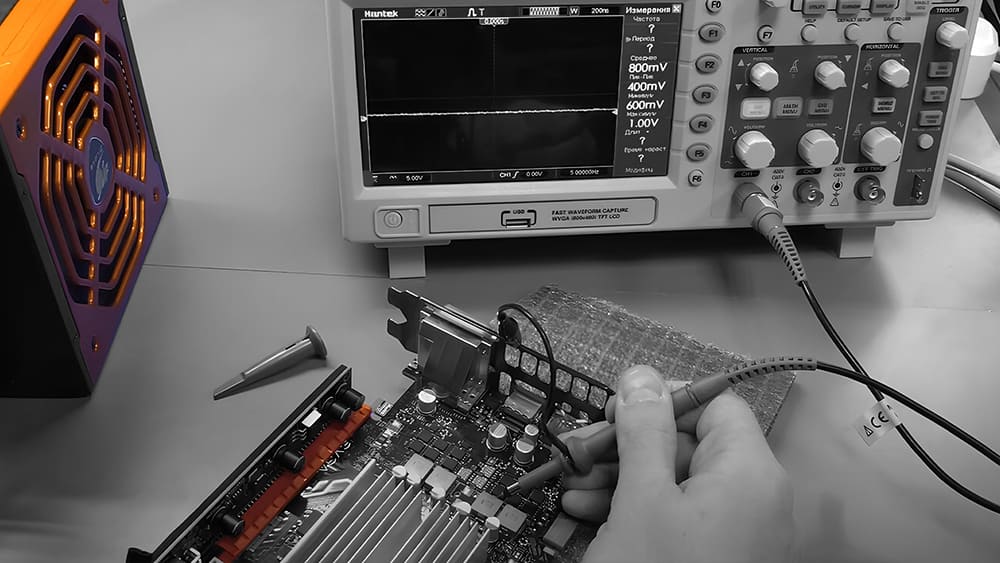 Рука с осциллографом диагностирует материнскую плату видеокарты EVGA, анализируя сигналы перед ремонтом.