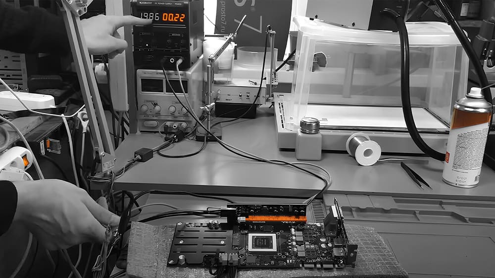 Специалист настраивает блок питания, подключенный к видеокарте EVGA для тестирования и диагностики перед ремонтом.